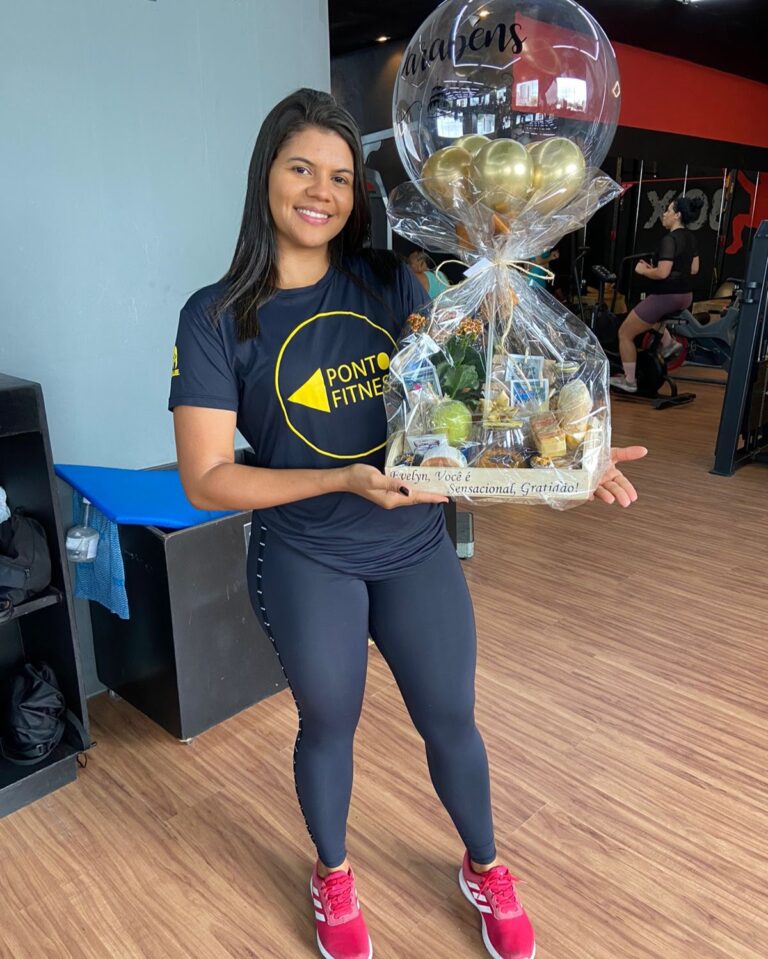 Cliente do sexo feminino, feliz por receber uma linda Cesta de café da manhã com balão personalizado no seu trabalho.