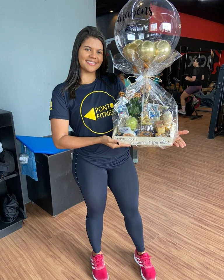 Cliente, feliz por receber uma linda Cesta de café da manhã com balão personalizado no seu trabalho.