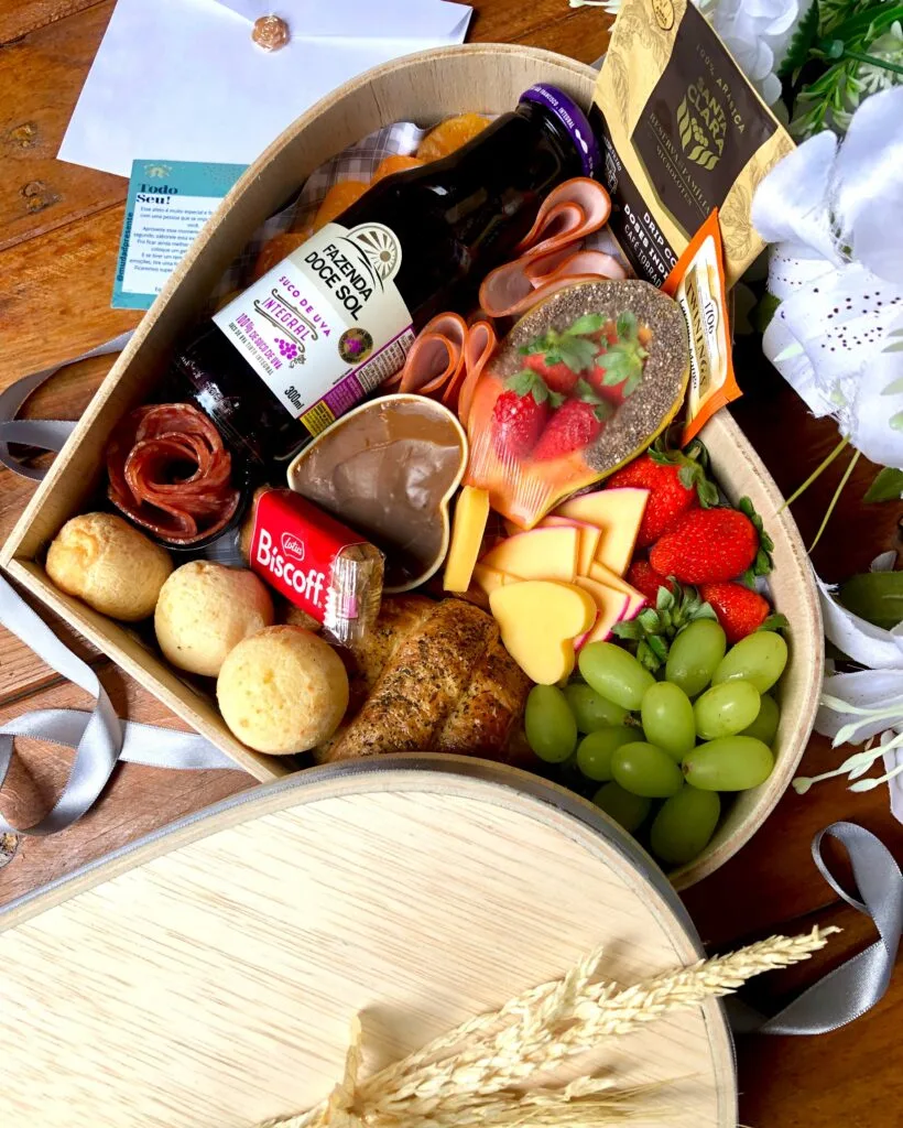 PLATTER CORAÇÃO BOM DIA Bom Dia com Amor ❤️ Itens: Mamão Decorado Morango Suco Integral Pão de Queijo Doce de Leite Chá Importado Biscoitinho Lotus Amêndoas Lombo Canadense Queijo do Reino Queijo Formato Coração Salame Italiano Damasco Croassant Uvas Drippe Coffee Caixa em Madeira formato Coração Foto Polaroide Cartaozinho com Mensagem Mini Buquê Flores Permanentes Balão Metalizado Taxa de entrega calculada de acordo com a localização 🚘 Importante ‼️ Caso haja algum dos produtos em falta no momento do envio, o mesmo poderá ser substituído por outro item de mesmo valor e qualidade.